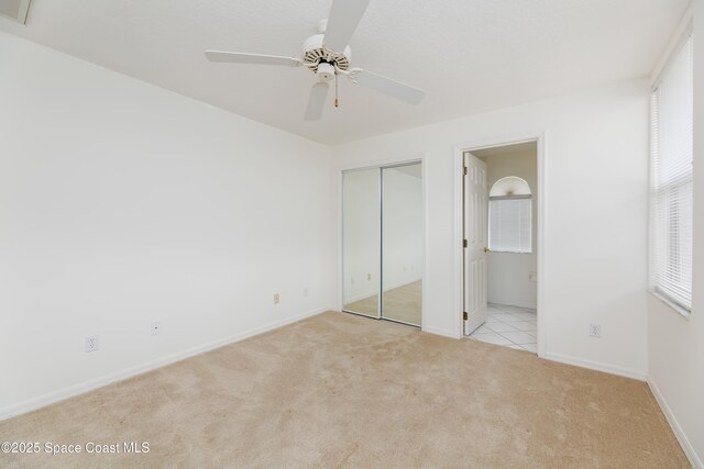 7433 Monterey Ct, Melbourne, FL 32940 - unfurnished bedroom with carpet floors, connected bathroom, baseboards, a closet, and ceiling fan