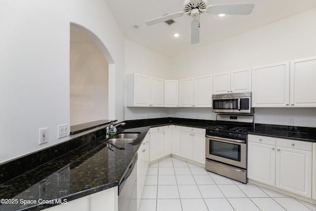 7433 Monterey Ct, Melbourne, FL 32940 - kitchen with appliances with stainless steel finishes, a sink, white cabinets, dark stone countertops, and ceiling fan