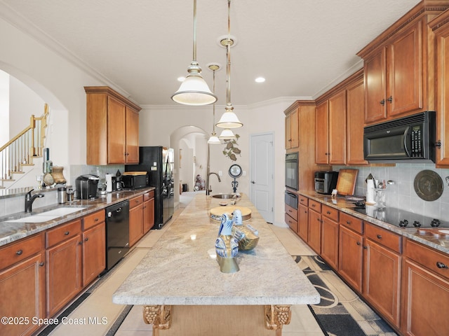 1013 Balmoral Way, Melbourne, FL 32940 - kitchen with arched walkways, black appliances, a kitchen island with sink, a warming drawer, and decorative backsplash