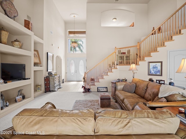1013 Balmoral Way, Melbourne, FL 32940 - carpeted living area featuring a high ceiling, stairs, built in features, and arched walkways