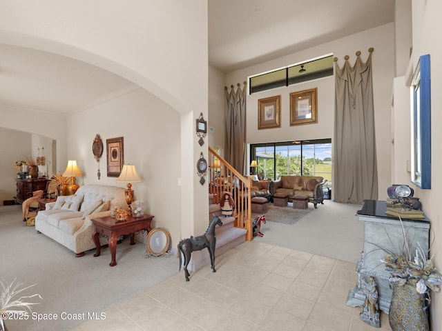 1013 Balmoral Way, Melbourne, FL 32940 - tiled living room with carpet flooring, arched walkways, a high ceiling, stairway, and crown molding