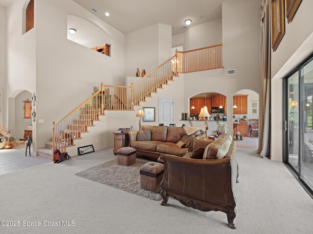 1013 Balmoral Way, Melbourne, FL 32940 - living area with arched walkways, carpet floors, stairway, and a towering ceiling