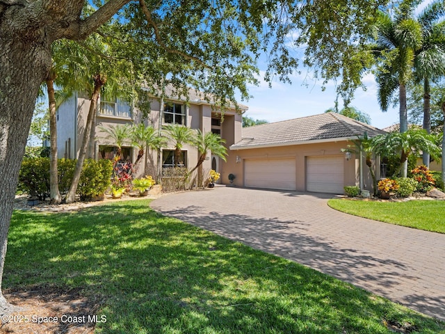 1013 Balmoral Way, Melbourne, FL 32940 - view of front of home featuring an attached garage, decorative driveway, stucco siding, a front lawn, and a tiled roof