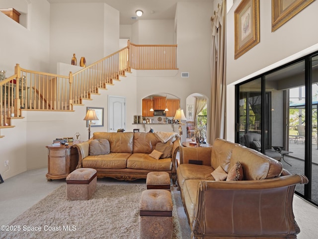 1013 Balmoral Way, Melbourne, FL 32940 - carpeted living area featuring a towering ceiling and stairs