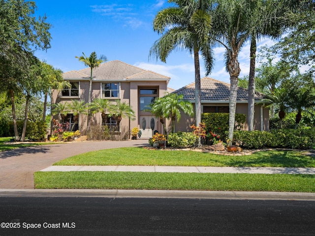 1013 Balmoral Way, Melbourne, FL 32940 - mediterranean / spanish-style house with a tile roof, decorative driveway, and a front lawn