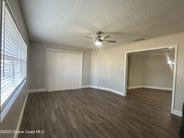 unfurnished bedroom with dark wood-type flooring, a textured ceiling, baseboards, and a ceiling fan