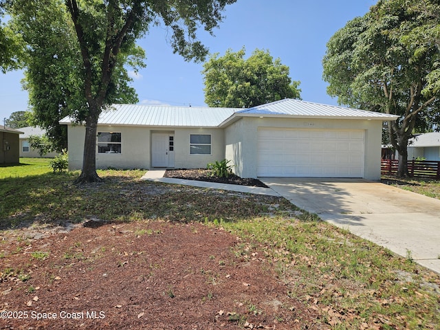 single story home featuring stucco siding, fence, a garage, and metal roof