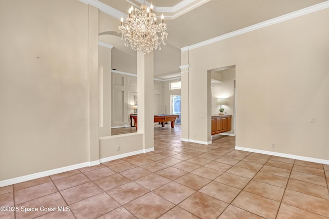 empty room with ornamental molding, light tile patterned flooring, a high ceiling, pool table, and a chandelier
