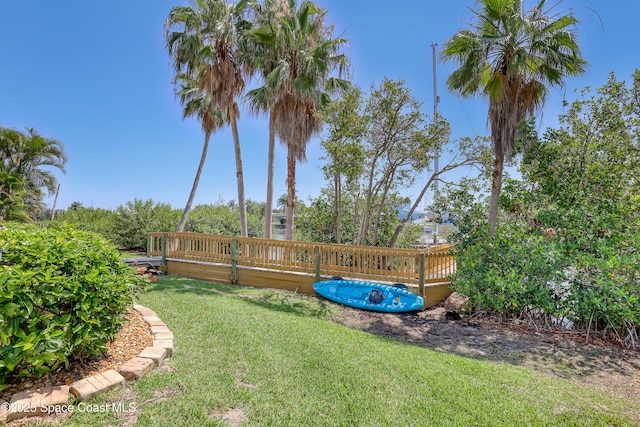 view of green lawn featuring a deck