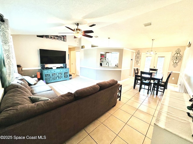 164 Bayamo Ave NE, Palm Bay, FL 32907 - living area with light tile patterned floors, vaulted ceiling, a ceiling fan, a textured ceiling, and baseboards