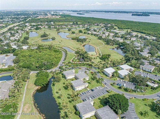 view of property location featuring a large body of water, nearby suburban area, and a golf club