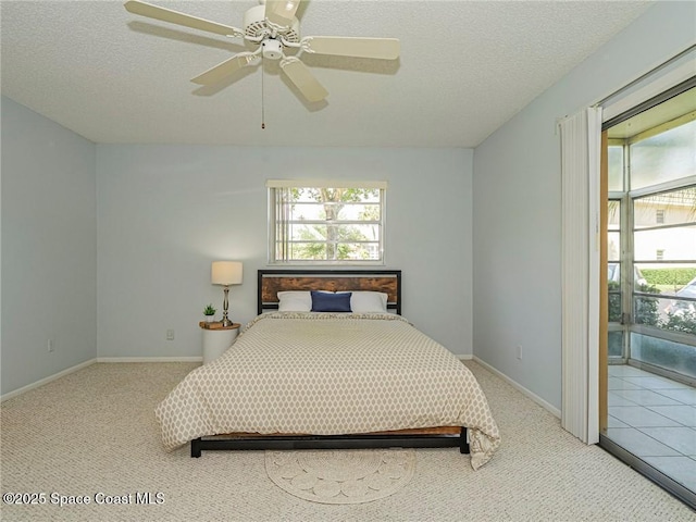 carpeted bedroom with a textured ceiling, baseboards, and ceiling fan
