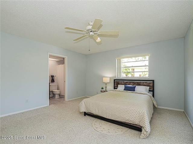 carpeted bedroom with baseboards, ensuite bath, ceiling fan, and a textured ceiling