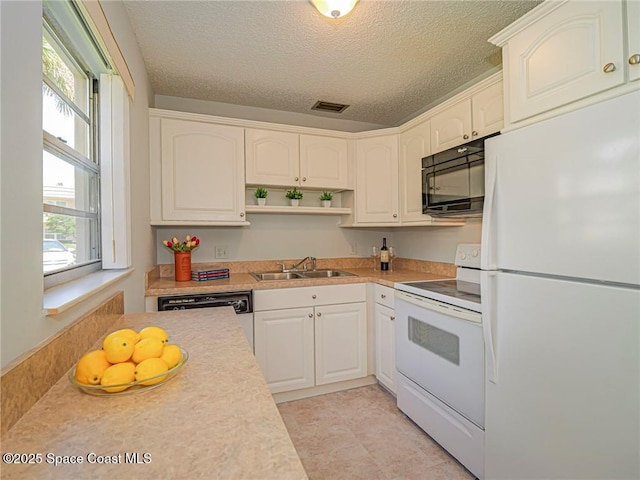 kitchen with white appliances, a sink, open shelves, a textured ceiling, and light countertops