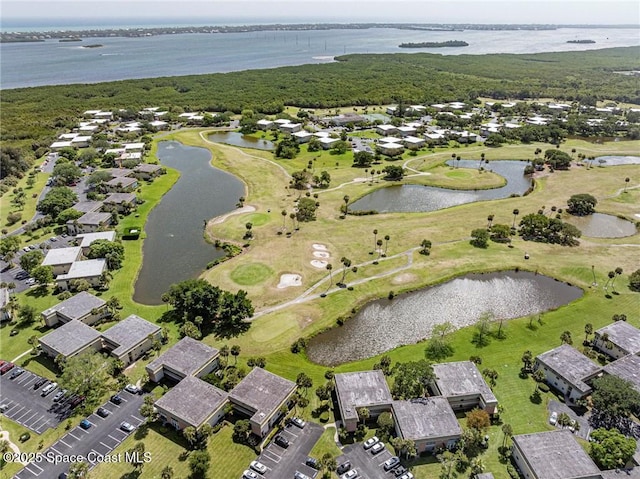 view of property location with a large body of water, nearby suburban area, and a golf club