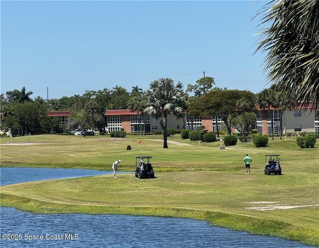 view of home's community with a lawn and a water view