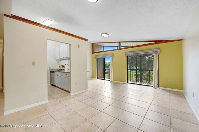 1600 Woodland Dr Unit 4206, Rockledge, FL 32955 - unfurnished room with light tile patterned floors, baseboards, a sink, vaulted ceiling, and a textured ceiling