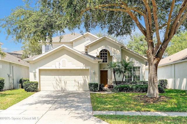2648 Daulby St, Kissimmee, FL 34747 - view of front facade featuring a garage, driveway, stucco siding, central AC, and a front lawn