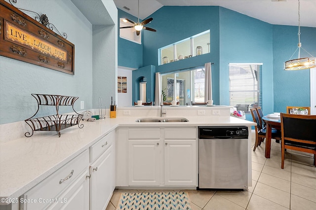 2648 Daulby St, Kissimmee, FL 34747 - kitchen with stainless steel dishwasher, a sink, ceiling fan, light tile patterned floors, and white cabinetry