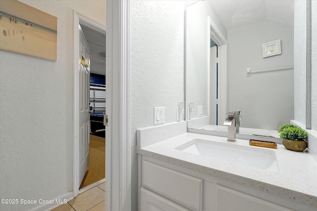 2648 Daulby St, Kissimmee, FL 34747 - bathroom with a textured wall, tile patterned flooring, vanity, and vaulted ceiling