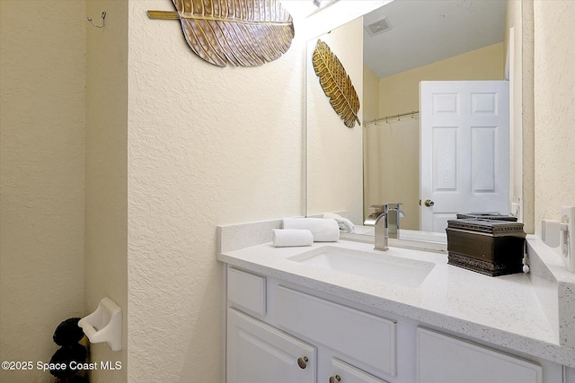 2648 Daulby St, Kissimmee, FL 34747 - bathroom with a textured wall, vanity, and lofted ceiling