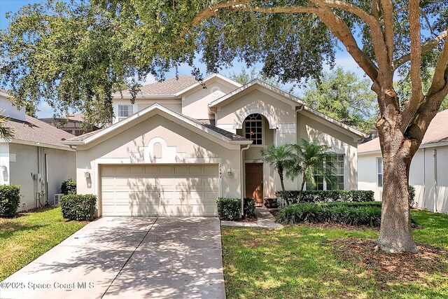 2648 Daulby St, Kissimmee, FL 34747 - mediterranean / spanish home with a garage, stucco siding, driveway, and a front yard
