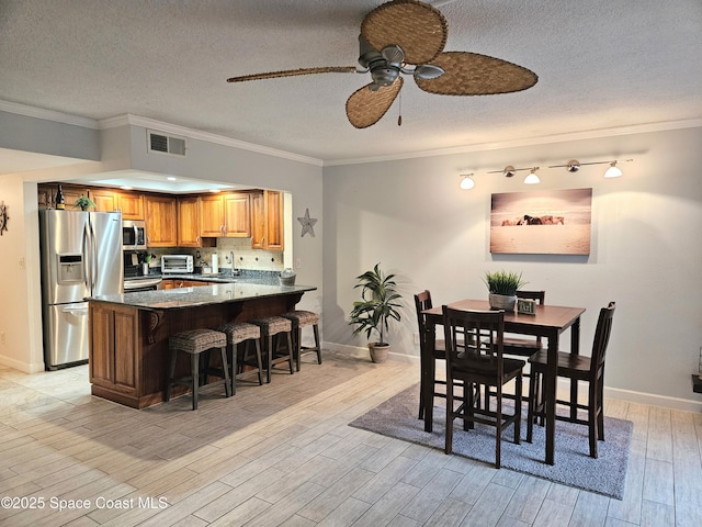 1700 S Atlantic Ave Unit 107, Cocoa Beach, FL 32931 - dining room with ceiling fan, light wood-type flooring, ornamental molding, baseboards, and a textured ceiling