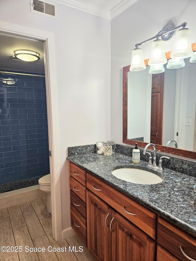 1700 S Atlantic Ave Unit 107, Cocoa Beach, FL 32931 - bathroom featuring ornamental molding, vanity, a shower stall, wood finish floors, and toilet
