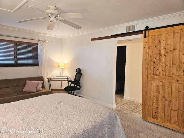 1700 S Atlantic Ave Unit 107, Cocoa Beach, FL 32931 - bedroom with wood finished floors, ornamental molding, a barn door, ceiling fan, and baseboards