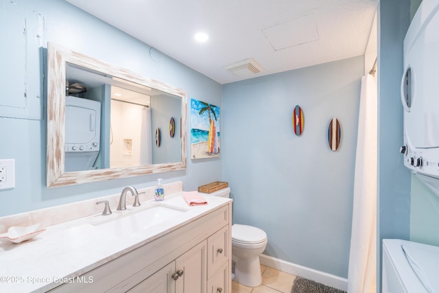 1145 S Atlantic Ave Unit B, Cocoa Beach, FL 32931 - bathroom featuring stacked washer / dryer, tile patterned floors, toilet, vanity, and baseboards