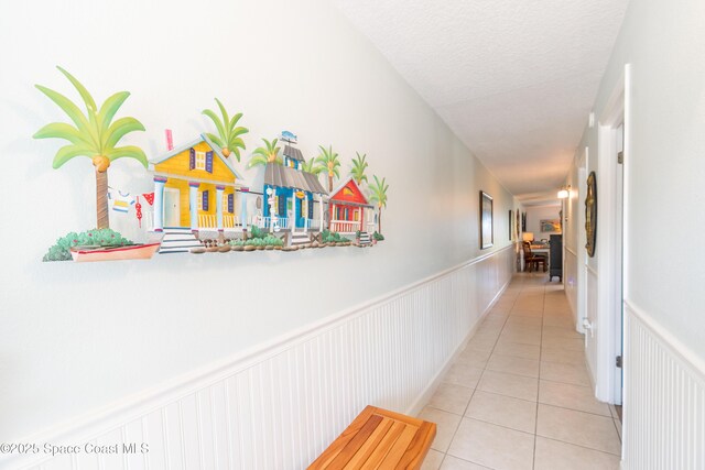 1145 S Atlantic Ave Unit B, Cocoa Beach, FL 32931 - hallway with light tile patterned floors, wainscoting, and a textured ceiling