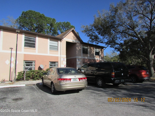 view of front of property with uncovered parking and stucco siding