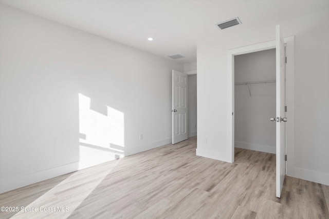 3258 Forghun Ave SE, Palm Bay, FL 32909 - unfurnished bedroom with light wood finished floors, a walk in closet, baseboards, recessed lighting, and a closet