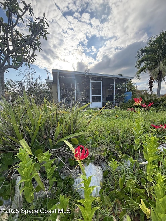 rear view of property featuring a sunroom