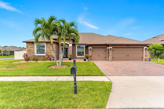 293 Adamo Way, Melbourne, FL 32904 - ranch-style home with stone siding, a garage, decorative driveway, stucco siding, and a front lawn