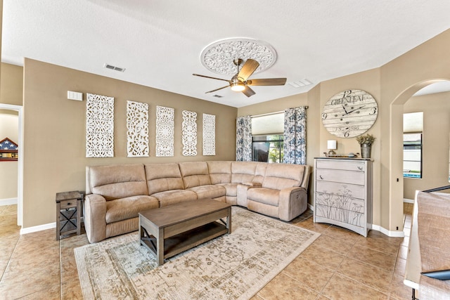 293 Adamo Way, Melbourne, FL 32904 - living area with arched walkways, ceiling fan, light tile patterned floors, baseboards, and a textured ceiling