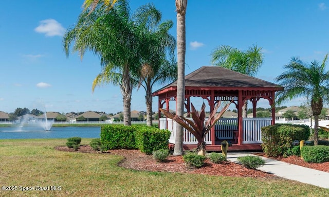 view of property's community with a gazebo, a yard, and a water view