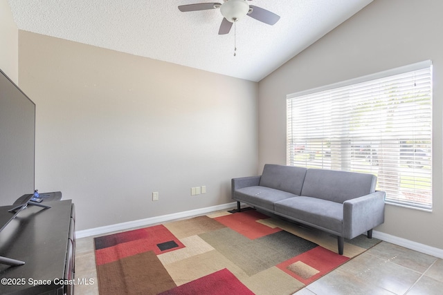 sitting room with lofted ceiling, a ceiling fan, baseboards, and a textured ceiling
