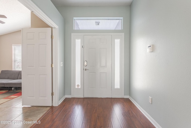 entryway with wood finished floors, ceiling fan, and baseboards