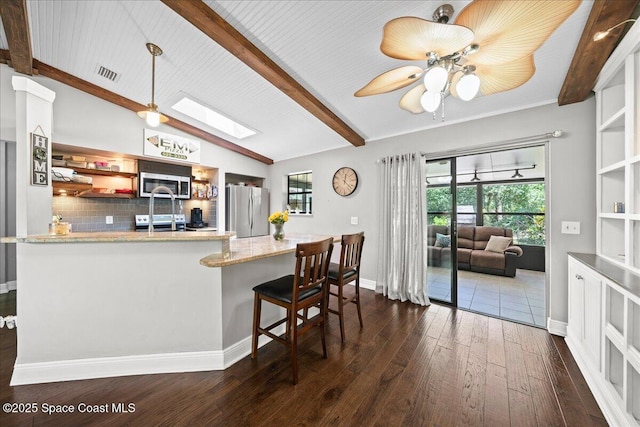 kitchen featuring stainless steel appliances, dark wood finished floors, decorative backsplash, and plenty of natural light