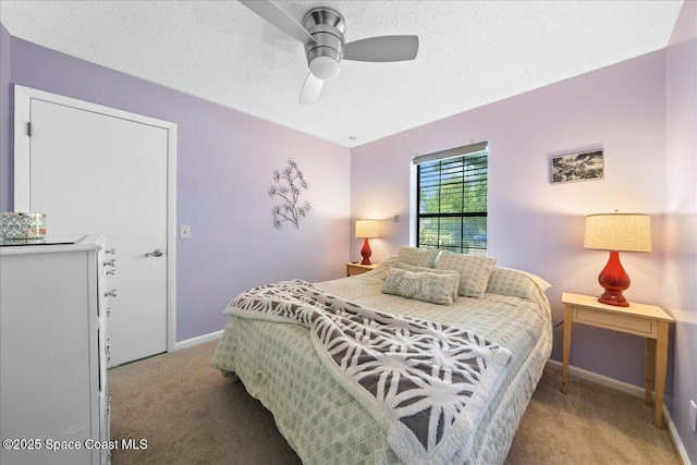 bedroom with light carpet, baseboards, a textured ceiling, and a ceiling fan