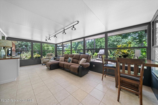 sunroom / solarium featuring tile patterned flooring and rail lighting