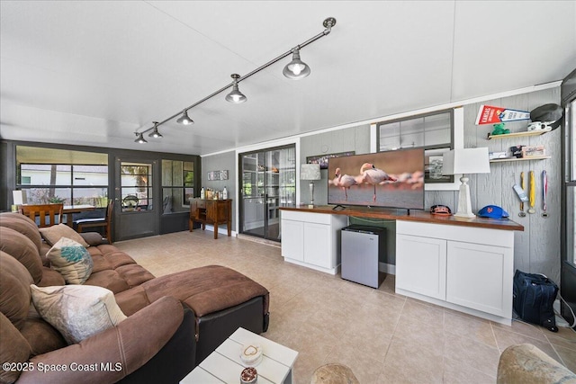 living area with track lighting and light tile patterned floors