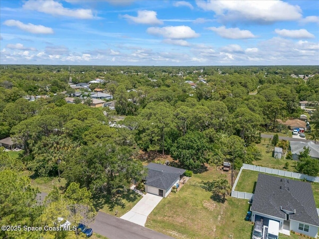aerial view of property and surrounding area with a forest and nearby suburban area