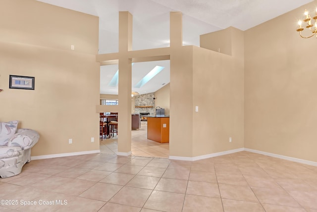 2805 Forest Run Dr, Melbourne, FL 32935 - unfurnished living room with high vaulted ceiling, light tile patterned flooring, a chandelier, baseboards, and a skylight