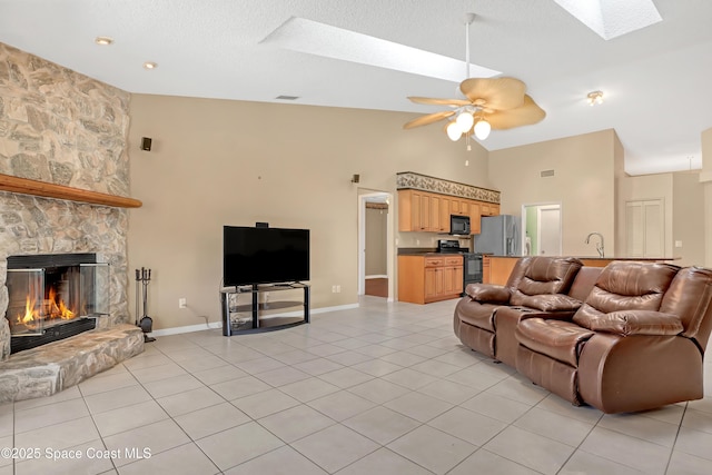 2805 Forest Run Dr, Melbourne, FL 32935 - living area featuring a skylight, high vaulted ceiling, a ceiling fan, light tile patterned flooring, and a stone fireplace