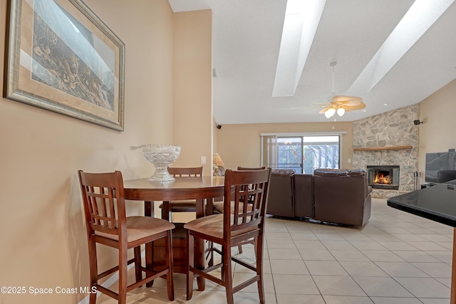 2805 Forest Run Dr, Melbourne, FL 32935 - dining room with ceiling fan, a fireplace, light tile patterned floors, a skylight, and lofted ceiling