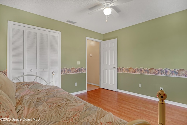 2805 Forest Run Dr, Melbourne, FL 32935 - bedroom with wood finished floors, baseboards, a closet, ceiling fan, and a textured ceiling