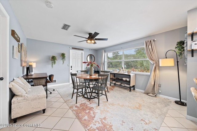 dining space featuring light tile patterned floors, a ceiling fan, baseboards, and a desk