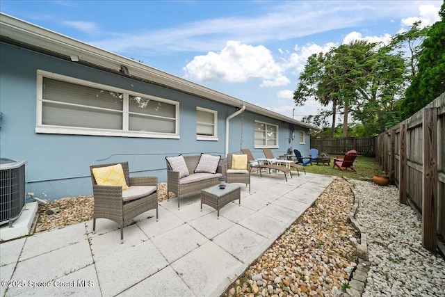 view of patio with a fenced backyard, central AC, and an outdoor living space with a fire pit
